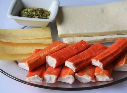 Завитушки с крабовыми палочками и сыром.Нам потребуется:Тесто слоёное 250 гКрабовые палочки 180 гСыр ...