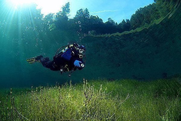 Водолаз плавает в кристально чистом озере Самерангер в Тироле, Австрия. Фотография была сделана на ...