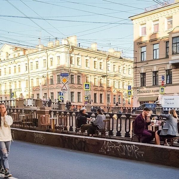 На набережной канала Грибоедова заведения общепита выставили столики, за ними сидят посетители кафе. ...
